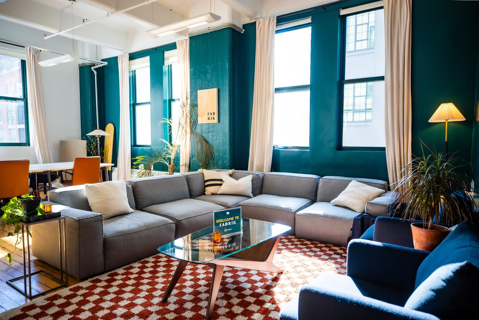 The lounge at Fabrik Dumbo: teal walls, deep sofas and a checkered rug.